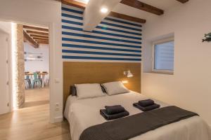 圣卡洛斯拉腊皮塔El Mariner的一间卧室配有一张带蓝白色条纹墙的床