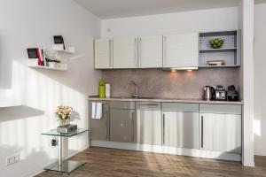 柏林罗森塔尔公寓式酒店的厨房配有不锈钢用具和白色橱柜