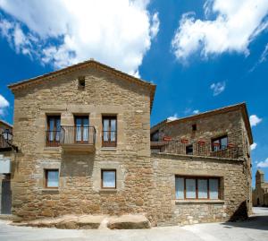 Masoteras帕劳艾特德斯盖拉旅馆的一座古老的石头建筑,设有窗户和阳台