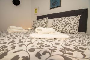 伊洛克Izvor的卧室配有一张带白色床单和枕头的大床。