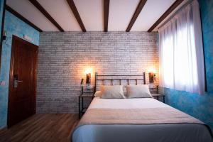 钦琼Palacito de la Rubia的一间卧室设有一张带砖墙的大床