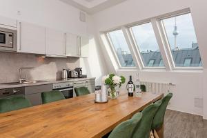 柏林罗森塔尔公寓式酒店的厨房配有木桌和绿色椅子