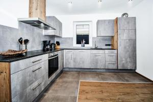 平茨高谷地霍勒尔斯巴赫Kitz Juwel Top 1的厨房配有不锈钢橱柜和黑色台面
