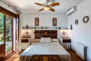 弗里希利亚纳Villa Cortijo del Peñón的一间卧室配有一张床和吊扇