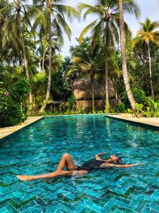 伯里塔卡Gitana del Mar Boutique Beach Resort的躺在度假村游泳池中的女人