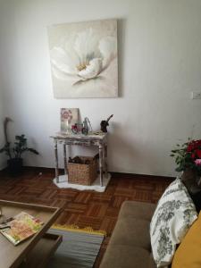洛斯·亚诺斯·德·阿里丹Townhouse Los Llanos de Aridane, La Palma的客厅配有桌子,墙上挂着一幅花画