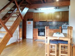 普拉德埃米塔Apartament Ca de Gallisca的厨房配有木制橱柜和木桌。