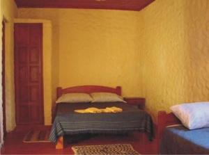 圣玛利亚Cabañas Achalay的黄色间内一间卧室,配有一张床