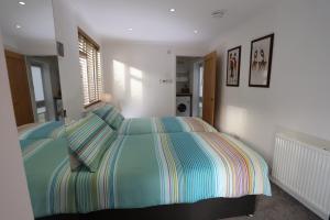 加拉希尔斯Tweedbank的一间卧室配有带条纹被子的床