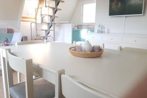 东代恩凯尔克Gezellige chalet in Nieuwpoort - Opkuis al inbegrepen in de prijs的白色的厨房配有白色的桌子和椅子