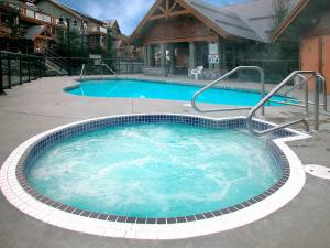 惠斯勒冰川里奇全季出租度假屋的一座房子前面的蓝色海水大型游泳池