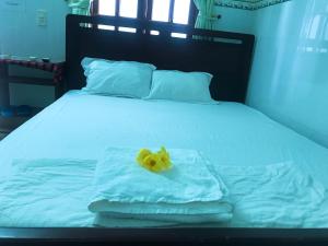 美奈Anh Linh Guest House的床上毛巾上方的黄色花朵