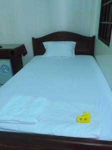 美奈Anh Linh Guest House的一张床上有白色的床单和黄色的水果