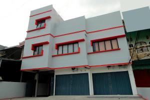 明古鲁省Super OYO 1678 Jati Exclusive Homestay的白色的建筑,有红色的窗户和门