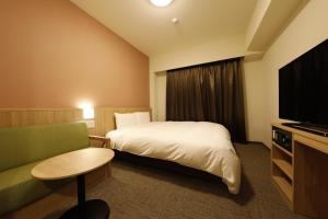 水户多米水户酒店(Dormy Inn Mito)的酒店客房,配有床和电视