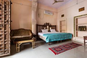 焦特布尔Heritage Gouri Haveli的一间卧室配有一张床和一张沙发