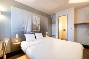 塞克兰B&B HOTEL Lille Seclin的窗户客房内的一张大白色床