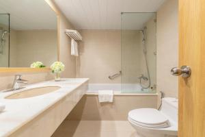 河内河内酒店的浴室配有盥洗盆、卫生间和浴缸。