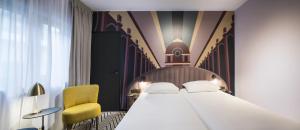 布鲁塞尔Hotel Hubert Grand Place的一间卧室配有一张床和一张黄色椅子