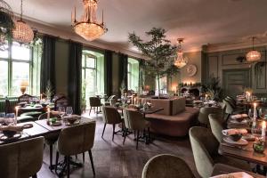 斯德哥尔摩阿克斯霍夫斯洛特酒店的一间带桌椅和吊灯的餐厅