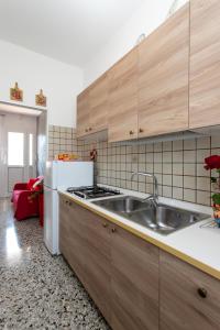 利多迪耶索罗Appartamenti Bedin, JESOLO LIDO的厨房配有木制橱柜、水槽和冰箱。