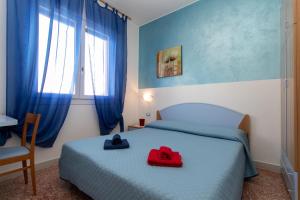 利多迪耶索罗Appartamenti Bedin, JESOLO LIDO的一间卧室,配有一张带两顶帽子的床