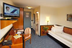 纽伦堡Advantage Appartements Hotel的配有一张床和一台平面电视的酒店客房