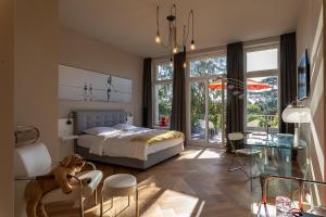 海因斯贝格Villa Glanzstoff的卧室配有一张床和一张桌子及椅子