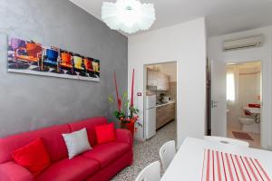 利多迪耶索罗Appartamenti Bedin, JESOLO LIDO的客厅配有红色的沙发和桌子