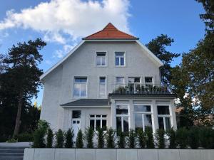 海因斯贝格Villa Glanzstoff的一座白色的大房子,有橙色的屋顶