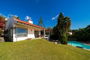 卡尼索Villa Albatroz的一座带庭院和游泳池的房子