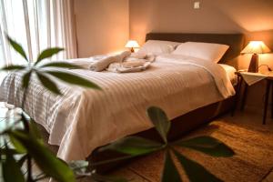 纳夫普利翁API Projects Nafplio - Family Superior Apartment的卧室配有白色床、两盏灯和植物