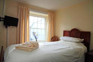 登特The Sun Inn的一间卧室配有一张带白色床单的床和一扇窗户。