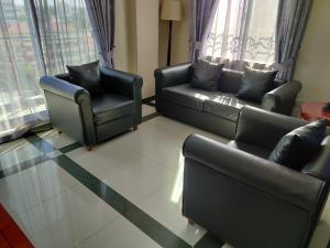 达累斯萨拉姆日航大厦酒店的客厅配有两张沙发和两把椅子