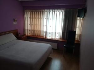 奥维多阿尔瓦雷斯旅舍的一间卧室配有床和带窗帘的窗户