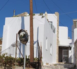 KóstosGuesthouse Casa De La Roca , Kostos , Paros的白色建筑一侧的镜子