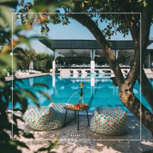 普里什蒂纳花园酒店的一张带桌椅的游泳池的照片