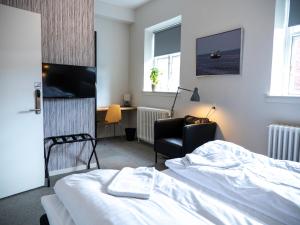 斯泰厄Hotel Residens Møen的一间卧室配有一张床、一张桌子和一把椅子