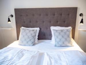 斯泰厄Hotel Residens Møen的一张带两个枕头的白色床和一个大床头板