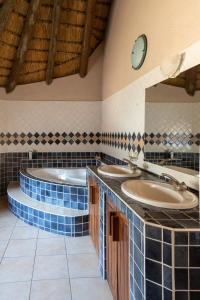 KamanjabOndundu Lodge的浴室配有2个盥洗盆和1个浴缸。