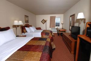 布兰森All American Inn & Suites Branson的酒店客房设有两张床和一台平面电视。