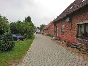 拉尔斯维克Ferienwohnung Ralswiek, Jarnitz 8的路边有车的建筑物旁的砖路