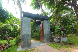 拉迈Zara Beach Resort Koh Samui - SHA Extra Plus Certified的花园里的一座小房子,设有木门