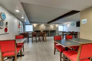 皮茨顿Holiday Inn Express Pittston - Scranton Airport, an IHG Hotel的用餐室配有木桌和红色椅子