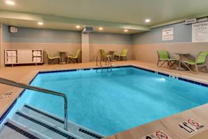 皮茨顿Holiday Inn Express Pittston - Scranton Airport, an IHG Hotel的游泳池位于酒店客房内,配有桌椅