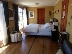 瓦尔帕莱索曼诺尔阿特金森酒店的一间卧室配有一张床,铺有木地板