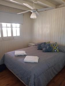 巴里尼奥Las Huellas Cabaña的一间卧室配有一张带两个枕头的床和吊扇