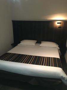 罗德兹罗德兹基里亚德酒店的一间卧室配有一张大床和黑色床头板