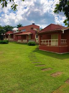 克拉鲁河畔卡尔穆Pousada Pontal do Lago的前面有草坪的红色房子