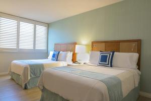 洛杉矶圣莫尼卡盖特威酒店的酒店客房,配有两张蓝色和白色的床